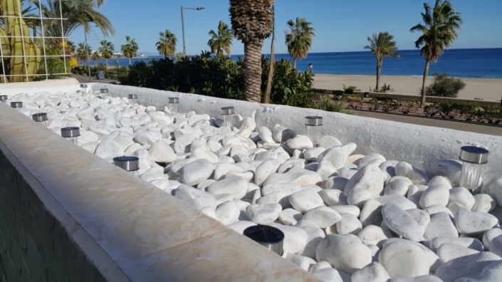 baranda terraza piedras decorativas blancas luces solares