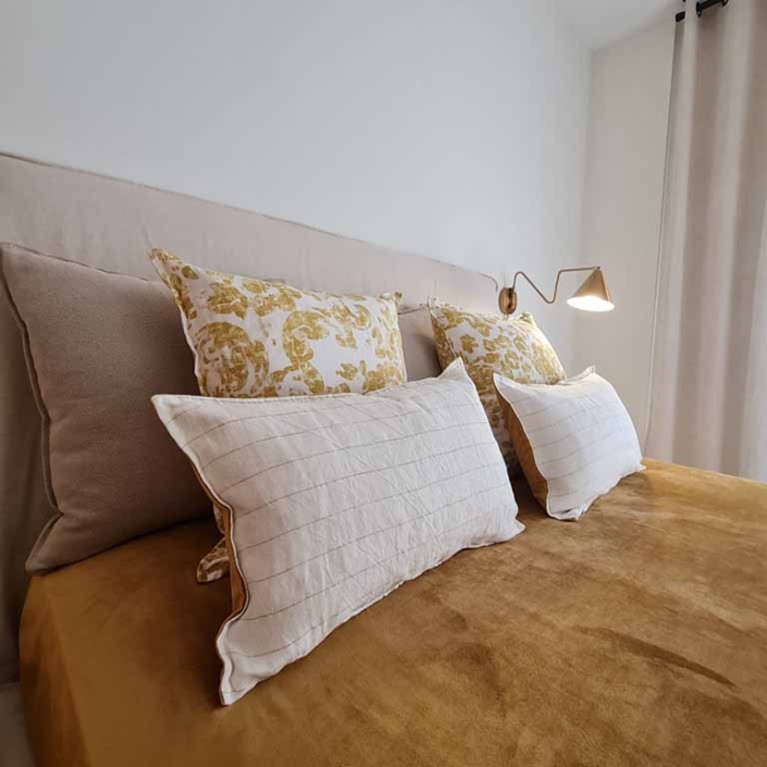 cama cojines lampara pared