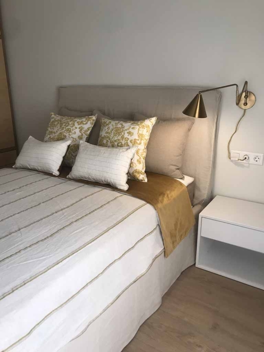 cama cojines lampara pared dorada