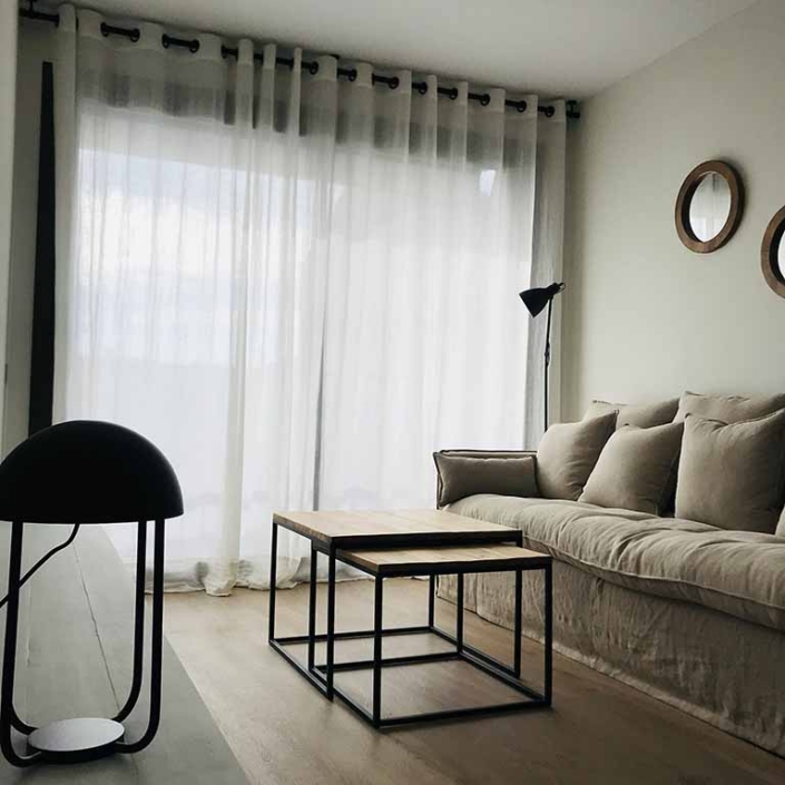 sofa cojines mesas auxiliares lampara balcon cortinas