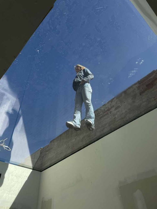 mujer camina encima claraboya cristal casa
