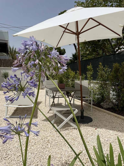 rehabilitacion-integral-casa-unifamiliar-castelldefels-jardin-mobiliario parasol blanco mesa sillas tumbona jardin