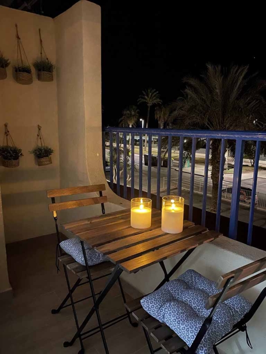 balcon mesa sillas velas noche vista paseo palmeras