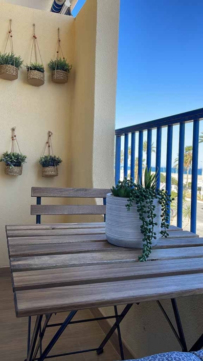 plantas colgadas pared mesa balcon sillas